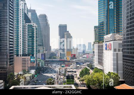 Guardando lungo Asoke Montri Road o Sukhumvit Soi 21 nella città di Bangkok, Thailandia. Lo skytrain BTS può essere visto lasciando la stazione di Asoke sullo sfondo. Foto Stock