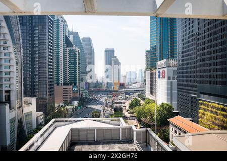 Guardando lungo Asoke Montri Road o Sukhumvit Soi 21 nella città di Bangkok, Thailandia. Lo skytrain BTS può essere visto lasciando la stazione di Asoke sullo sfondo. Foto Stock