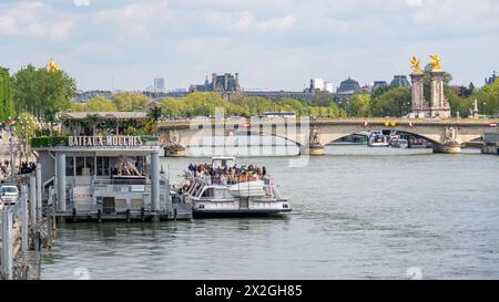 Argine Bateaux-Mouches con il ponte Pont Alexandre III sullo sfondo. I Bateaux-Mouches sono barche escursionistiche che visitano la Senna a Parigi Foto Stock