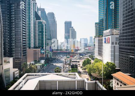 Guardando lungo Asoke Montri Road o Sukhumvit Soi 21 nella città di Bangkok, Thailandia. Lo skytrain BTS può essere visto lasciando la stazione di Asoke sullo sfondo. Foto Stock