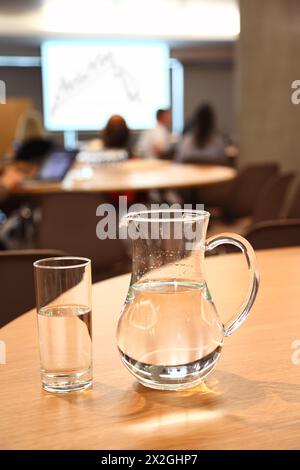 decanter e vetro con acqua pulita e pulita su un tavolo luminoso in camera Foto Stock