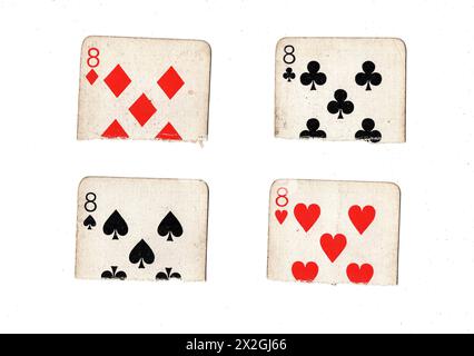 Metà strappate di carte da gioco vintage che mostrano un otto su tutte e quattro le tute su sfondo bianco. Foto Stock