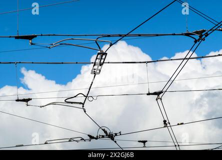 Cablaggio elettrico del traffico cittadino di tram e autobus - sullo sfondo una potente nuvola nel cielo blu Foto Stock