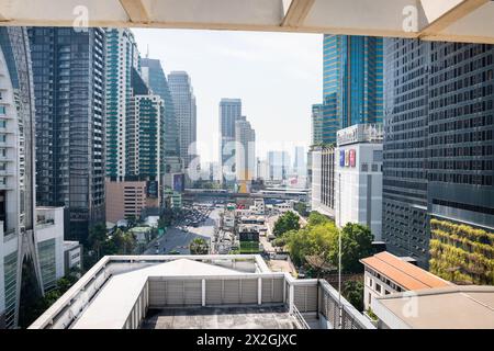 Guardando lungo Asoke Montri Road o Sukhumvit Soi 21 nella città di Bangkok, Thailandia. Lo skytrain BTS può essere visto lasciando la stazione di Asoke sullo sfondo. Foto Stock