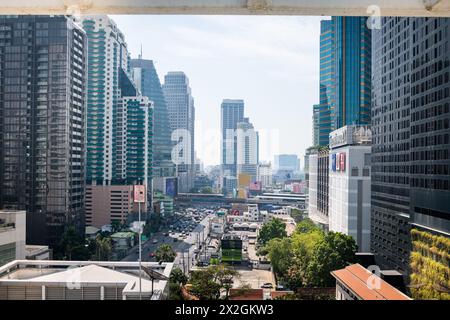 Guardando lungo Asoke Montri Road o Sukhumvit Soi 21 nella città di Bangkok, Thailandia. Lo skytrain BTS può essere visto lasciando la stazione di Asoke sullo sfondo. Foto Stock