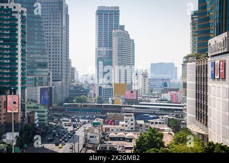 Guardando lungo Asoke Montri Road o Sukhumvit Soi 21 nella città di Bangkok, Thailandia. Lo skytrain BTS può essere visto lasciando la stazione di Asoke sullo sfondo. Foto Stock