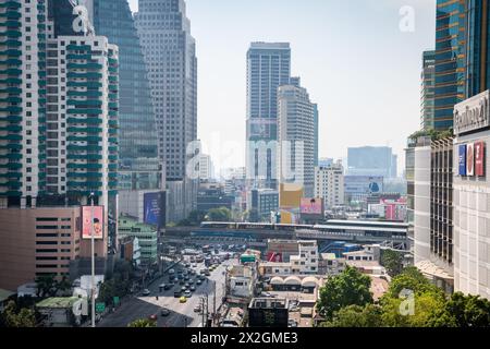 Guardando lungo Asoke Montri Road o Sukhumvit Soi 21 nella città di Bangkok, Thailandia. Lo skytrain BTS può essere visto lasciando la stazione di Asoke sullo sfondo. Foto Stock