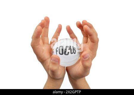 Mani del bambino che reggono una sfera di vetro isolata su sfondo bianco, con la parola messa a fuoco distorta Foto Stock