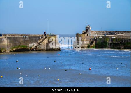 Una vista verso l'entrata del porto con la bassa marea a Saundersfoot, Galles, in una luminosa giornata primaverile Foto Stock