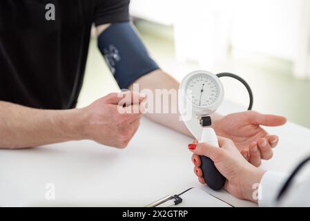 Un esperto medico si concentra sulla scrittura delle informazioni vitali in un ambiente clinico. Foto Stock