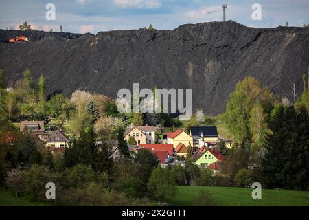 Hergisdorf, Germania. 18 aprile 2024. Un cumulo di scorie dei tempi dell'estrazione del rame domina il paesaggio accanto alla piccola città. Tra il 2020 e il 2040, si prevede che la popolazione di Mansfeld-Südharz diminuirà del 21,1%. Previsioni simili sono fatte per gli altri stati della Germania orientale. Allo stesso tempo, la percentuale di anziani è in aumento. I distretti stanno facendo del loro meglio per combattere questa situazione. Crediti: Jan Woitas/dpa/Alamy Live News Foto Stock