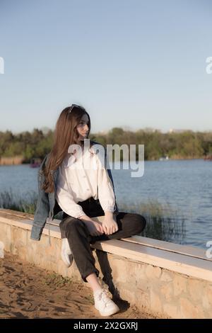 Ritratto di una bella ragazza con un libro. Sta succedendo da qualche parte nel parco. Primo piano. Foto Stock