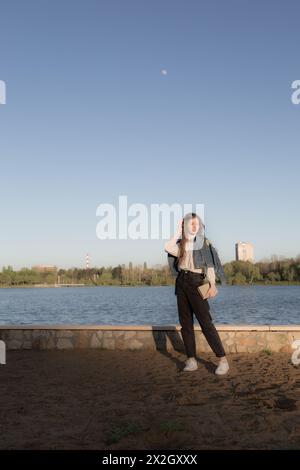 Ritratto di una bella ragazza con un libro. Sta succedendo da qualche parte nel parco. Primo piano. Foto Stock