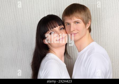 Giovane uomo felice e donna vestito con camicie bianche su sfondo bianco lavorato a maglia Foto Stock