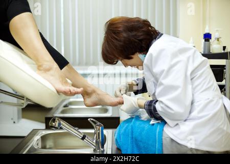 Il maestro chiropody elabora le unghie di una cliente femminile nel salone di bellezza Foto Stock