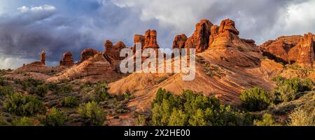 Dietro il parco giochi di rocce rosse calde del Garden of Eden nell'Arches National Park, vicino a Moab, Utah, si costruiscono spettacolari nuvole. Foto Stock