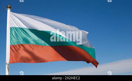 Die Fahne von Bulgarien flattert im Wind, isoliert gegen blauer Himmel Foto Stock