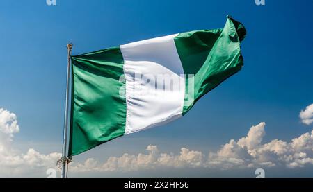 Die Fahne von Nigeria flattert im Wind, isoliert gegen blauer Himmel Foto Stock