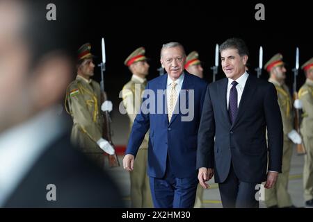 Erbil, Iraq. 22 aprile 2024. Il presidente della regione del Kurdistan in Iraq Nechirvan Barzani (R) riceve il presidente turco Recep Tayyip Erdogan durante una cerimonia di benvenuto presso l'aeroporto internazionale di Erbil (EIA). Credito: Ismael Adnan/dpa/Alamy Live News Foto Stock