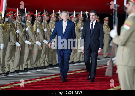 Erbil, Iraq. 22 aprile 2024. Il presidente della regione del Kurdistan in Iraq Nechirvan Barzani (R) riceve il presidente turco Recep Tayyip Erdogan durante una cerimonia di benvenuto presso l'aeroporto internazionale di Erbil (EIA). Credito: Ismael Adnan/dpa/Alamy Live News Foto Stock