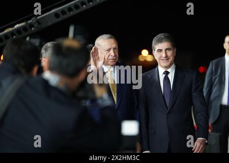 Erbil, Iraq. 22 aprile 2024. Il presidente della regione del Kurdistan in Iraq Nechirvan Barzani (R) riceve il presidente turco Recep Tayyip Erdogan durante una cerimonia di benvenuto presso l'aeroporto internazionale di Erbil (EIA). Credito: Ismael Adnan/dpa/Alamy Live News Foto Stock