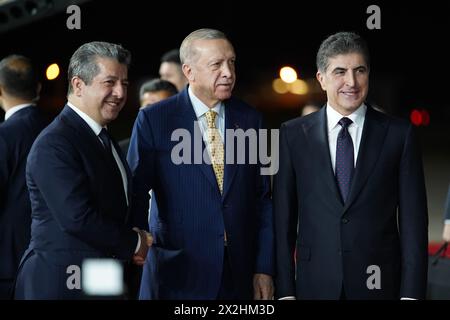 Erbil, Iraq. 22 aprile 2024. Il presidente della regione del Kurdistan in Iraq Nechirvan Barzani (R) e il primo ministro curdo iracheno Masrour Barzani (L) ricevono il presidente turco Recep Tayyip Erdogan (C) durante una cerimonia di benvenuto all'aeroporto internazionale di Erbil (EIA). Credito: Ismael Adnan/dpa/Alamy Live News Foto Stock