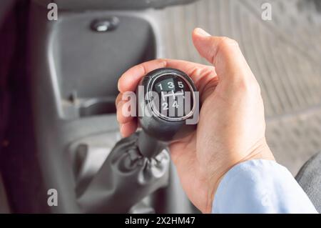 Colpo corto di un uomo d'affari che cambia le marce di un car.Hand che tiene il cambio manuale in auto. Foto Stock