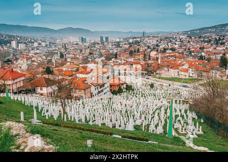 16 marzo 2024, Sarajevo, Bosnia ed Erzegovina: Il cupo cimitero di Sarajevo è un testimone silenzioso, con file di lapidi bianche che punteggiano l'hil Foto Stock