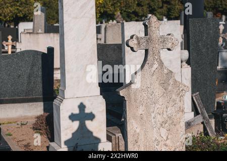In mezzo alla tranquilla serenità del cimitero, file di lapidi e croci si ergono come solenni monumenti ai defunti, un simbolo senza tempo di memoria Foto Stock