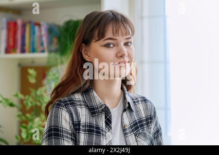 Ritratto di una ragazza sorridente che guarda la fotocamera a casa Foto Stock