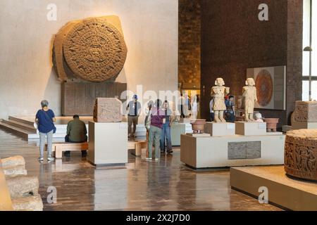 Persone nel Museo Nazionale di Antropologia, Messico - vista interna che include la pietra Azteca del Sole montata sul muro; città del Messico, Messico Foto Stock