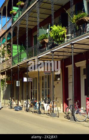 Le biciclette da consegna e da diporto sono bloccate sui pali degli edifici nel quartiere francese di New Orleans Foto Stock