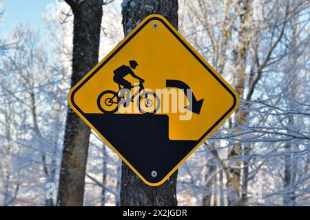 Sentiero per mountain bike, cartello di avvertimento di caduta improvvisa, cartello di avvertenza nero e giallo Foto Stock