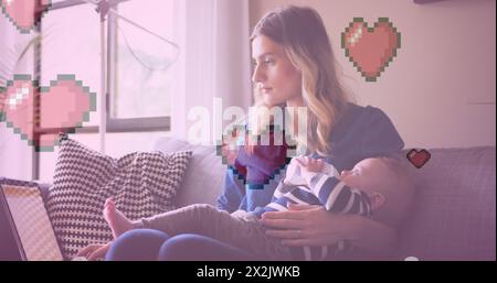 Immagine delle icone del cuore sulla madre caucasica che tiene in braccio il bambino Foto Stock