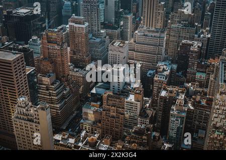 Un'ampia foto panoramica cattura un paesaggio urbano densamente ricco, mettendo in evidenza una serie di grattacieli marroni e beige sotto il cielo limpido. Foto Stock