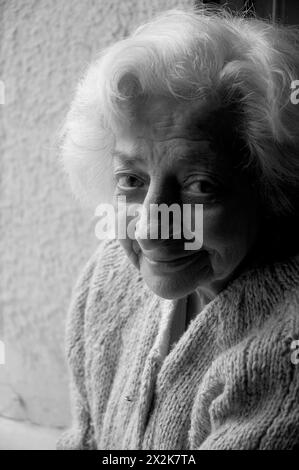 Ritratto di vecchia donna sorridente e guardando la telecamera. In bianco e nero. Foto Stock