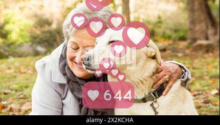 Immagine di icone dei social media con un numero crescente di persone rispetto a una donna caucasica anziana con il suo cane da compagnia Foto Stock