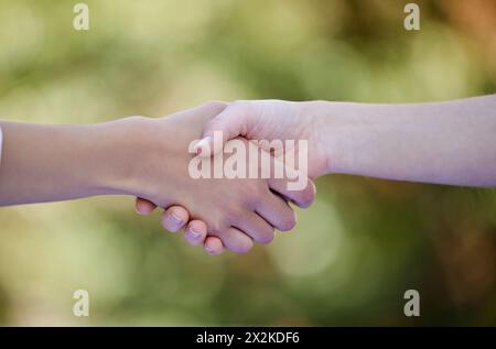 Lavoro di squadra, stretta di mano e mani di persone in natura per collaborazione, accordo e ringraziamento in Park. Amici, diversità e primo piano di gesti per Foto Stock