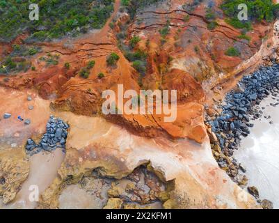 Vista aerea delle scogliere costiere erose con grandi crepe a Point Roadknight sulla Great Ocean Road a Victoria, Australia Foto Stock