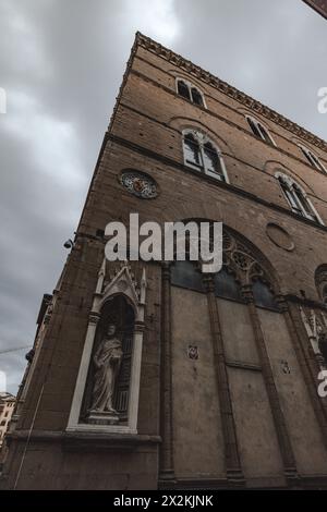 Scena di strada nel centro di Firenze in Toscana, Italia, con architettura classica vista dal livello della strada. Scattato in una giornata nuvolosa con un cielo grigio e lunare. Foto Stock