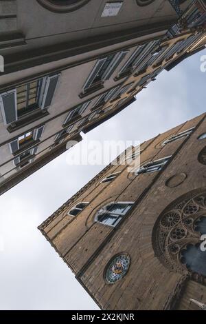Scena di strada nel centro di Firenze in Toscana, Italia, con architettura classica vista dal livello della strada. Scattato in una giornata nuvolosa con un cielo grigio e lunare. Foto Stock