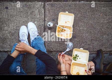 Concept, vista dall'alto di due turisti che mangiano da asporto in strada al Camden Market di Londra Foto Stock