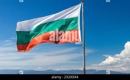 Die Fahne von Bulgarien flattert im Wind, isoliert gegen blauer Himmel Foto Stock