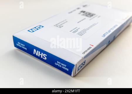 Londra. REGNO UNITO- 04.17.2024. Un kit di test del cancro intestinale isolato in bianco, inviato dal servizio sanitario Nazionale per posta. Foto Stock