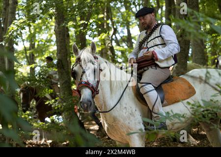 A Illinden (Festa della Repubblica), i ciclisti vestiti tradizionalmente viaggiano da Skopje, la capitale, a Meckin. Kamen, Macedonia del Nord Foto Stock