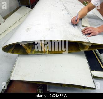 12 aprile 2024, Sassonia, Lipsia: Nel centro tecnico del campus dell’Università di scienze applicate (HTWK), l'assistente alla ricerca Dimitrij Seibert del team guidato dal professore HTWK di costruzione leggera con materiali compositi Robert Böhm prepara una parte di una pala del rotore della turbina eolica di 25 anni smontata per una prova delle sue proprietà meccaniche. Le indagini fanno parte di EuReCOMP, un progetto di ricerca collaborativa finanziato dall'UE che mira a sviluppare metodi sostenibili per il riciclaggio e il riutilizzo di materiali compositi provenienti da componenti dell'energia eolica, tra l'altro. Scienziati Foto Stock