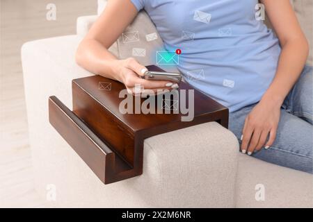 E-mail. Donna che usa il cellulare a casa, primo piano. Illustrazioni in lettere intorno al dispositivo Foto Stock