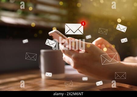 E-mail. Donna che usa il cellulare in casa, primo piano. Illustrazioni in lettere intorno al dispositivo Foto Stock