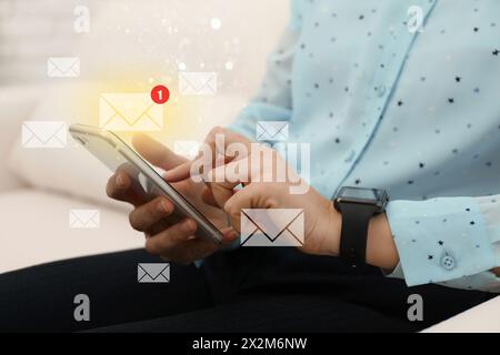 E-mail. Donna che usa il cellulare a casa, primo piano. Illustrazioni in lettere intorno al dispositivo Foto Stock