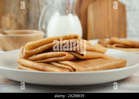 Blini, blintze, crepe russe impilate sul piatto su fondo di composizione rustica. Foto Stock